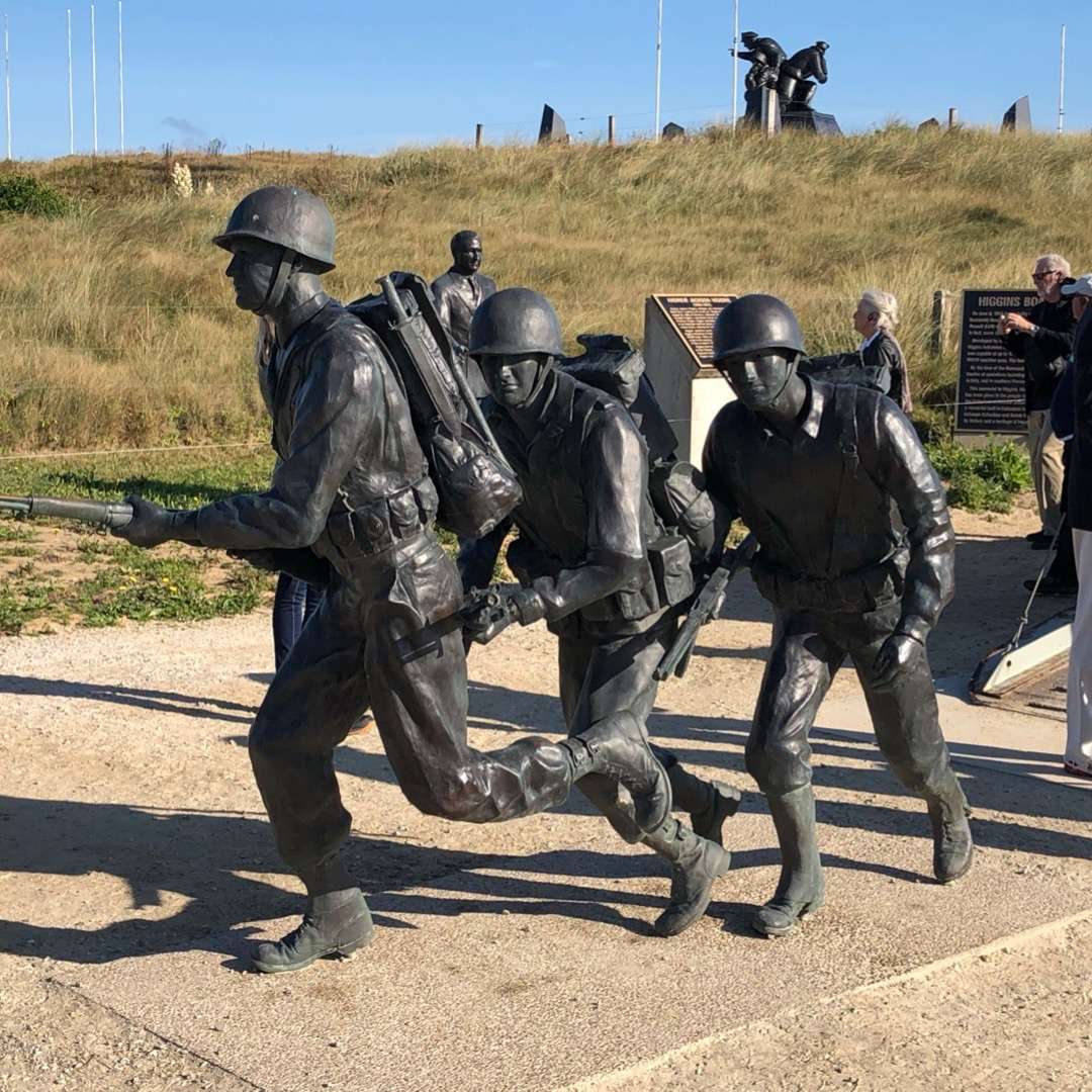 Statues of soldiers with guns drawn at Normandy